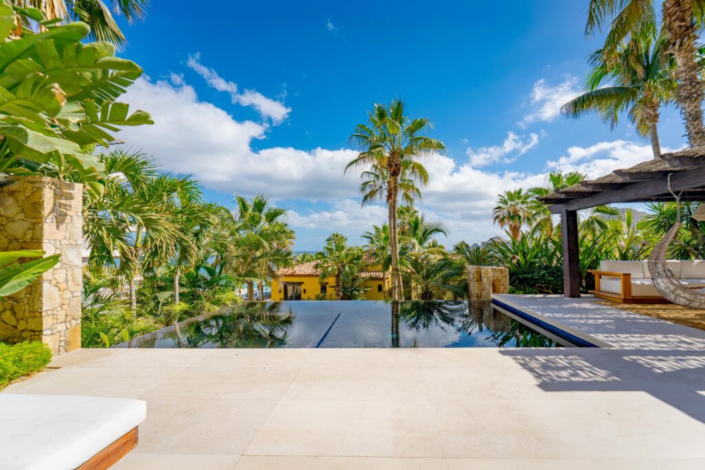 Los Cabos Luxury Hacienda Csl This fully renovated three-bedroom property offers a seamless indoor-outdoor layout designed for comfortable coastal living.The private terrace features a pool, hot tub, BBQ area, and a dedicated outdoor bar, complemented by a shaded lounge and seating area surrounded by mature landscaping, ideal for entertaining or everyday relaxation. The ground-level setting allows easy access to outdoor spaces while maintaining privacy. Inside, the residence has been completely updated with clean, modern finishes and a functional floor plan. Bedrooms are well sized and thoughtfully distributed for both owners and guests. The layout includes a family suite / additional sleeping space (bunk room or flex sleeping area), allowing accommodation for up to 8 guests, offering greater flexibility than the typical 3-bedroom layout designed for six.Set in one of the most desirable areas of Cabo San Lucas, the property enjoys direct beach access and close proximity to the marina, restaurants, and services, all within the Hacienda Beach Club community. – 1102 Beachfront Hacienda, Cabo San Lucas, BS