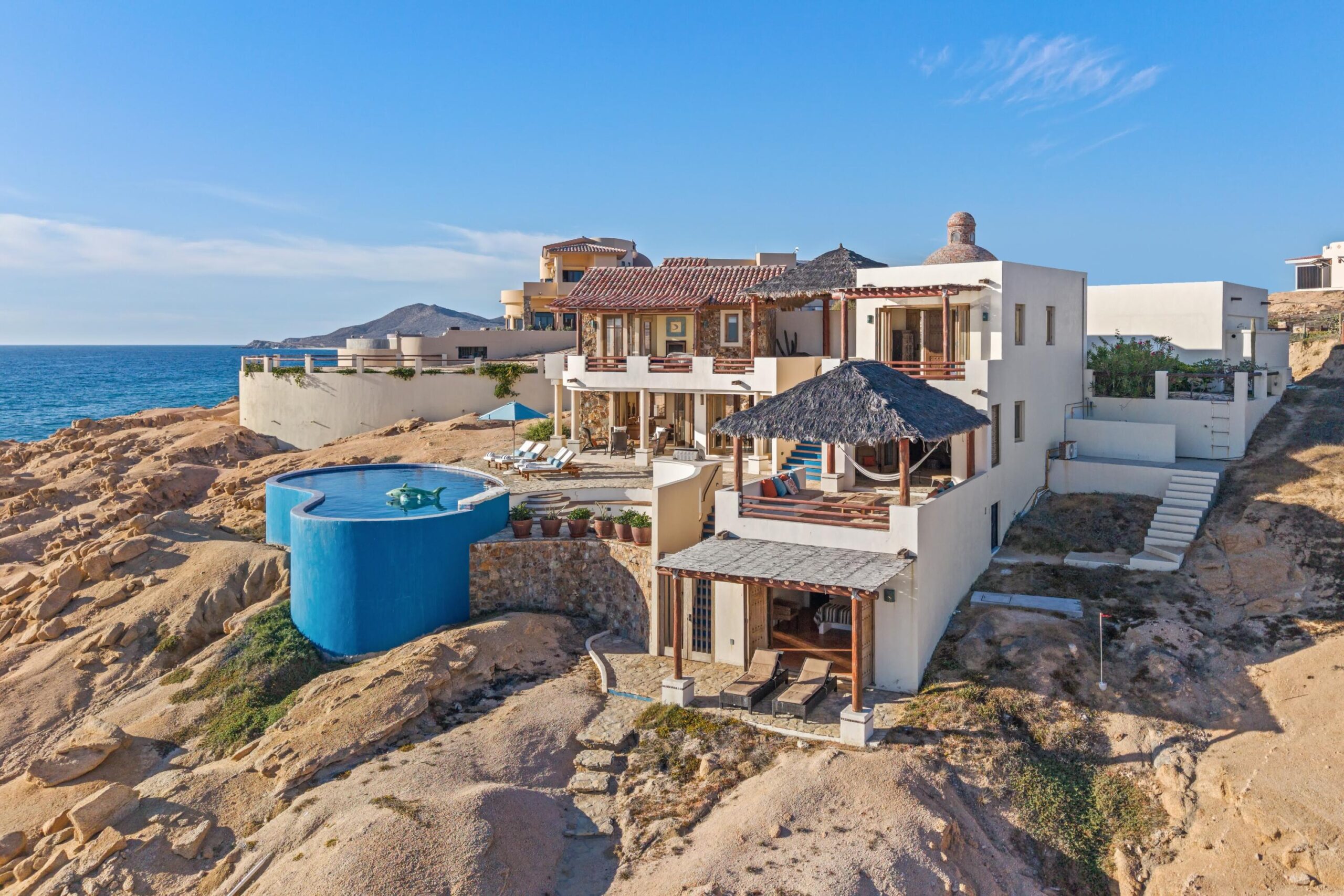Los Cabos Luxury Rancholasmargaritas Casa Playa Escondida - Oceanfront Luxury in Baja California SurPerched dramatically on the rocks above the Pacific Ocean, Casa Playa Escondida is a rare oceanfront retreat set along a secluded, pristine stretch of beach. Located within the exclusive off-grid gated community of Rancho Las Margaritas, this one-of-a-kind property offers privacy, tranquility, and breathtaking natural beauty--just a 20-minute drive to the dining and shopping of Cabo San Lucas, 40 minutes from Los Cabos International Airport, and approximately 30 minutes south of Cerritos and Todos Santos.The residence features three spacious ensuite bedrooms, each privately situated yet connected by terraces, pathways, and shared gathering spaces. A dedicated media room offers flexibility as a fourth bedroom or additional guest suite.Expansive terraces and multiple lounging areas provide a variety of vantage points to take in the surrounding landscape, from the rugged coastline to the endless Pacific horizon.The gourmet kitchen is equipped with high-end appliances and designed for both functionality and style. A warm and inviting living and dining area, anchored by a striking fireplace, creates the perfect space for entertaining or relaxing with family and friends. The home is offered fully furnished with includes modern off-grid conveniences such as solar power.Outdoor living is equally exceptional, featuring a swimming pool, firepit, grilling area, and multiple seating spaces--ideal for enjoying the serene coastal setting for sale